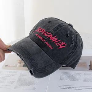 Detail der pinkfarbenen Stickerei auf einer verwaschenen grauen Baseballkappe