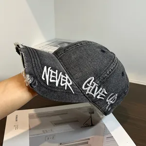 Detail of distressed brim and white NEVER GIVE UP embroidery on vintage washed baseball cap