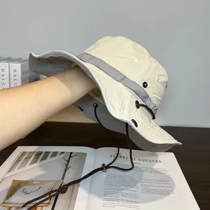 Detail view of quick-dry sun hat showing breathable metal eyelets and adjustable wind cord