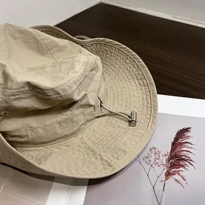 Detail of khaki hiking hat featuring wide brim stitching and adjustable chin strap