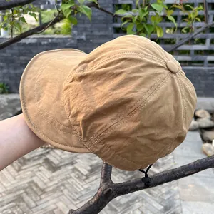 Detail of khaki nylon baseball cap with white stitching and adjustable toggle drawstring