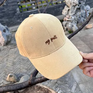Close-up of khaki cotton baseball cap with my putt embroidery in an outdoor garden setting