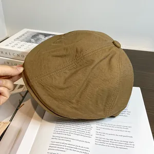 Détail d'une casquette rétro marron posée sur des pages de livre vintage et texture