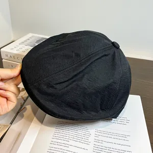 Vue détaillée du béret noir vintage avec bouton supérieur montrant la texture du tissu