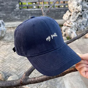 Detailed close-up of dark blue baseball cap featuring white my putt embroidery and stitching