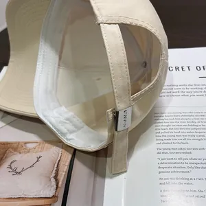 Detalle de gorra de béisbol beige con hebilla de metal y grabado de letras GZZF