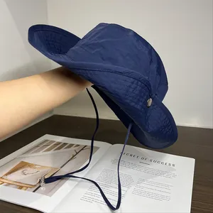 Detail of navy nylon hiking hat with adjustable chin strap and side metal snaps