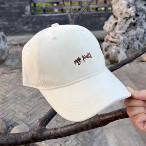 Close-up of cream baseball cap with brown my putt embroidery and cotton twill texture