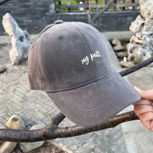 Detail of gray baseball cap featuring white 'my putt' embroidery and cotton canvas texture