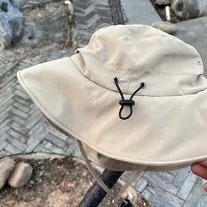 Detail of beige sun hat with adjustable drawstring and wide brim for UV protection