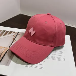 Detalle de gorra de béisbol rosa oscuro con bordado de la letra N en 3D sobre algodón