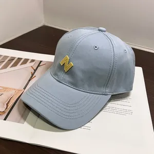 Primer plano de gorra de béisbol de algodón azul claro con bordado de letra N en amarillo