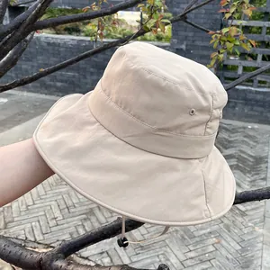 Detail view of beige wide-brim sun hat with adjustable windproof cord for outdoors
