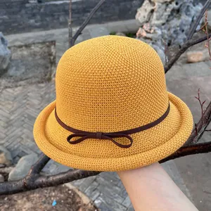 Detailed close-up of yellow crochet cloche hat with a bow and brown ribbon trim