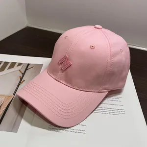 Detalle de gorra de béisbol de algodón rosa con bordado letra N y costura de visera