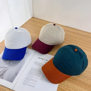 Close-up of three retro color-block cotton baseball caps on a textured wooden surface