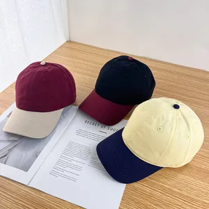 Three stylish contrast-color cotton baseball caps on a wooden table for street fashion