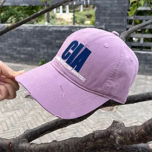 Close-up of vintage purple baseball cap featuring CIA embroidery and distressed brim details