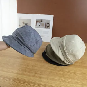 Gros plan de casquettes rétro en beige, vert et bleu sur une surface en bois
