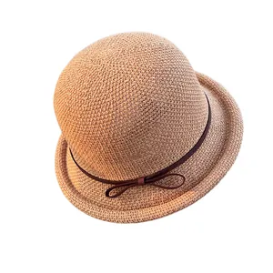 Women's straw sun hat with dome top and brown ribbon bow for summer beach travel