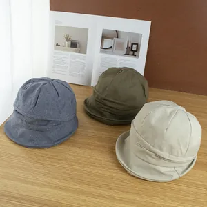 Chapeau de soleil en coton pour femme en bleu, vert et beige sur une table