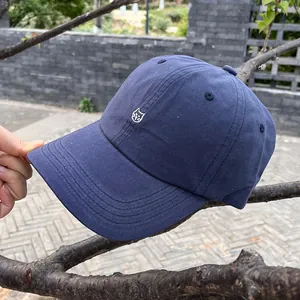 Vista dettagliata del ricamo del gatto bianco sul cappellino da baseball blu scuro
