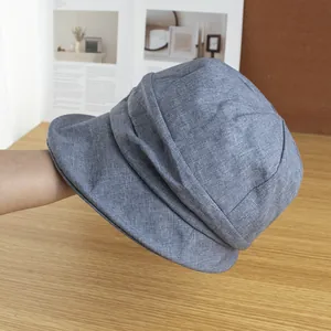 Vue détaillée du chapeau de soleil en lin bleu-gris avec texture plissée élégante