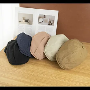 Set mit fünf atmungsaktiven Sommer-Schiebermützen in neutralen Farben auf Holztisch