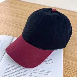 Detail view of contrast baseball cap with black crown and burgundy quilted visor on magazine