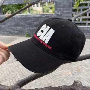 Detail of vintage black baseball cap featuring distressed brim and CIA embroidery
