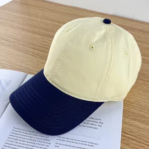 Detail of color-block baseball cap with navy brim on cream cotton fabric and embroidery