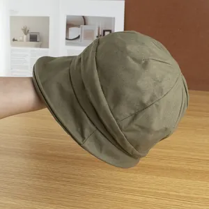 Détail d'un chapeau bob en toile vert olive montrant les coutures et la texture rétro