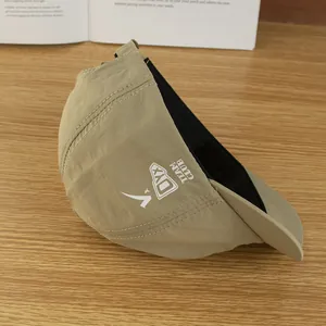 Detailopname van kaki waterdichte pet met DYX-logo op een houten bureau