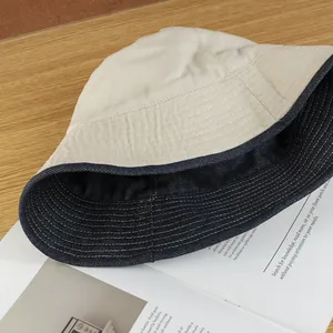 Reversible beige canvas and dark blue denim sun hat with reinforced white stitching