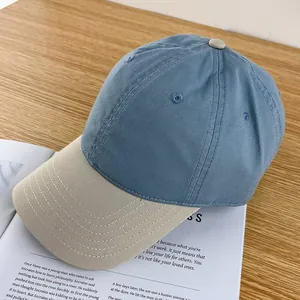 Detail of two-tone cotton baseball cap with beige brim and contrast blue-grey crown