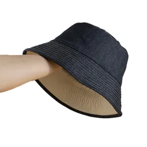Reversible blue denim sun bucket hat with white stitching and khaki inner lining
