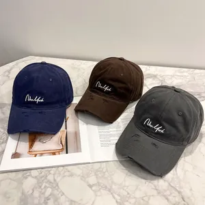 Tre berretti New York invecchiati nei colori navy, marrone e grigio su base in marmo