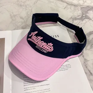 Vista dettagliata della visiera parasole blu e rosa con ricamo Authentic EST.1987 su marmo