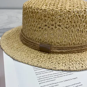 Détail du tissage de chapeau de paille avec corde rustique et boucle en cuir