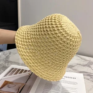 Detail of light yellow hand-knitted bucket hat with breathable hollow crochet pattern