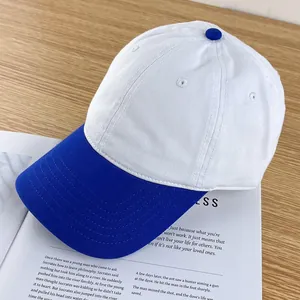 Detailed view of blue and white canvas baseball cap stitching on a wooden surface