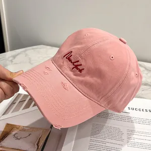 Primo piano del cappello da baseball rosa in cotone usurato con ricamo New York rosso