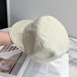 Close-up of beige woven linen texture and detailed stitching on a vintage newsboy cap