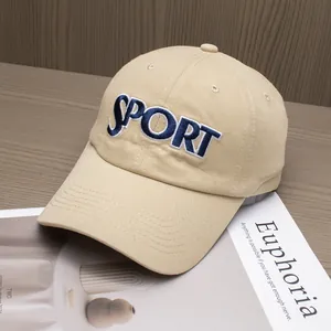 Detailed embroidery of navy blue SPORT letters on a beige cotton twill baseball cap