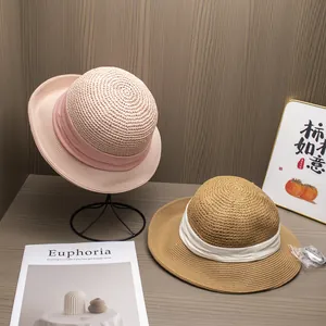 Détail de chapeaux de paille tissés main avec ruban élégant en rose et marron café