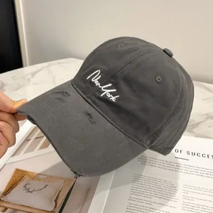 Dettaglio del cappellino in cotone grigio antracite con ricamo New York e visiera usurata