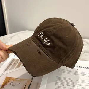 Dettaglio della visiera consumata e ricamo New York su cappellino di cotone marrone