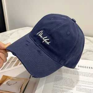 Dettaglio del cappello blu navy con visiera logorata e ricamo New York di alta qualità