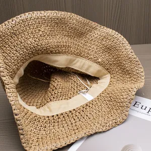 Macro detail of hand-woven straw hat showing sweatband, white label and texture