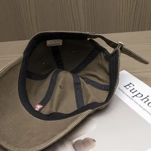 Detail of cotton baseball cap interior with TIAN HONG brand label and metal buckle
